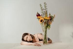 woman lying white table flowers